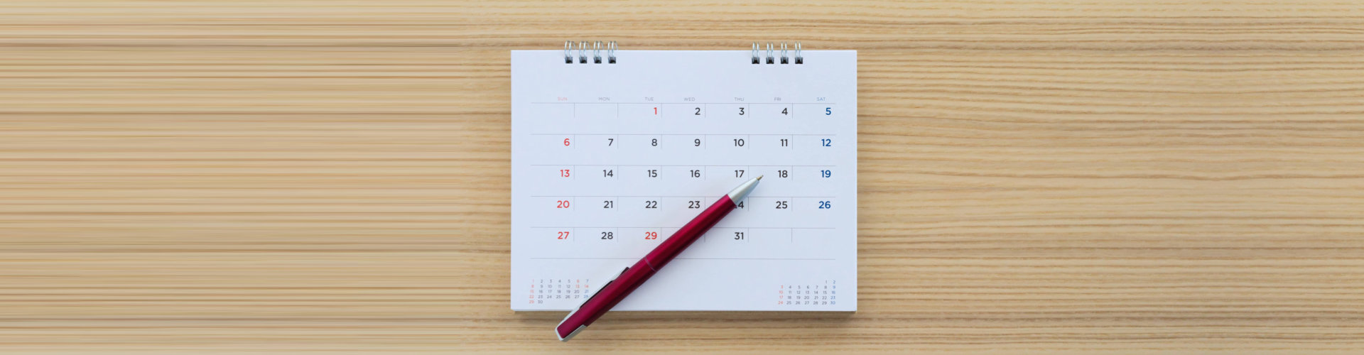 calendar and a pen on a wooden table